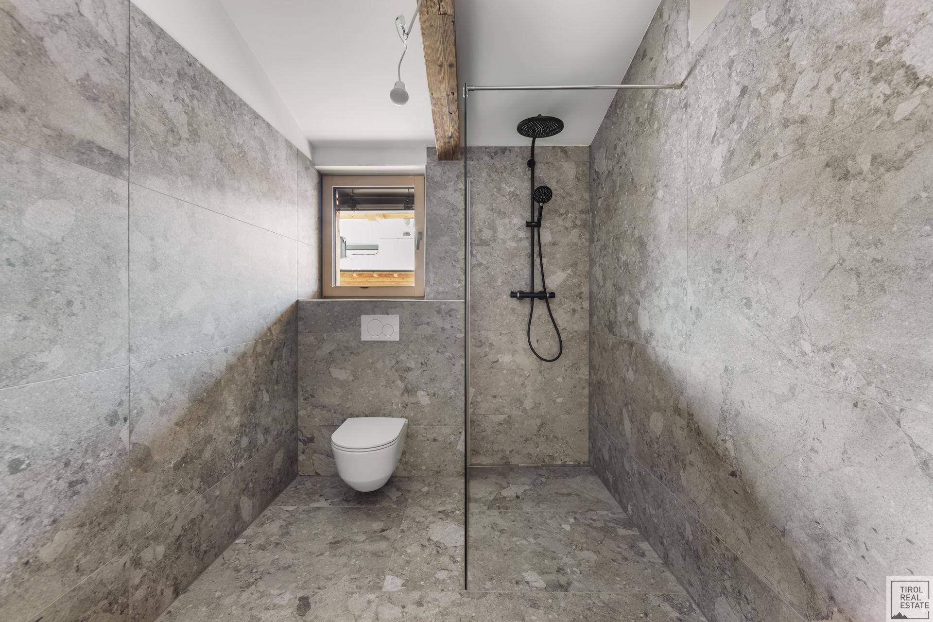 Modernes Badezimmer mit begehbarer Dusche, Wand-WC und Fenster für Tageslicht.