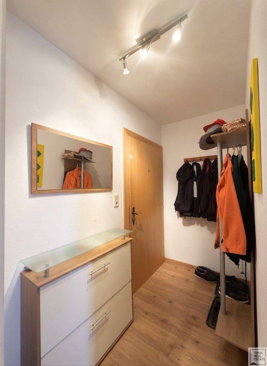 Eingangsbereich mit Schuhschrank, Spiegel und Garderobe, ideal für den Empfang.