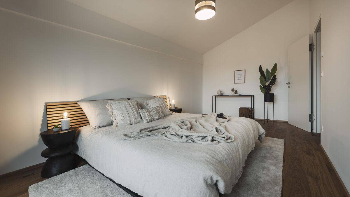 Geräumiges Schlafzimmer mit Holzboden, modernem Bett und minimalistischer Einrichtung.