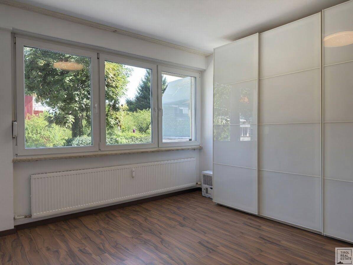 Helles Schlafzimmer mit geräumigem Einbauschrank und Blick auf die umliegende Natur.