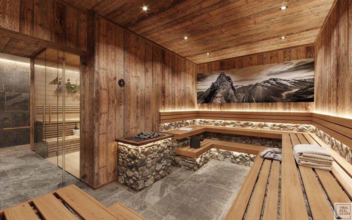 Entspannungsbereich der Sauna mit Holzbänken, Steinwänden und einem großen Bergpanorama-Bild.