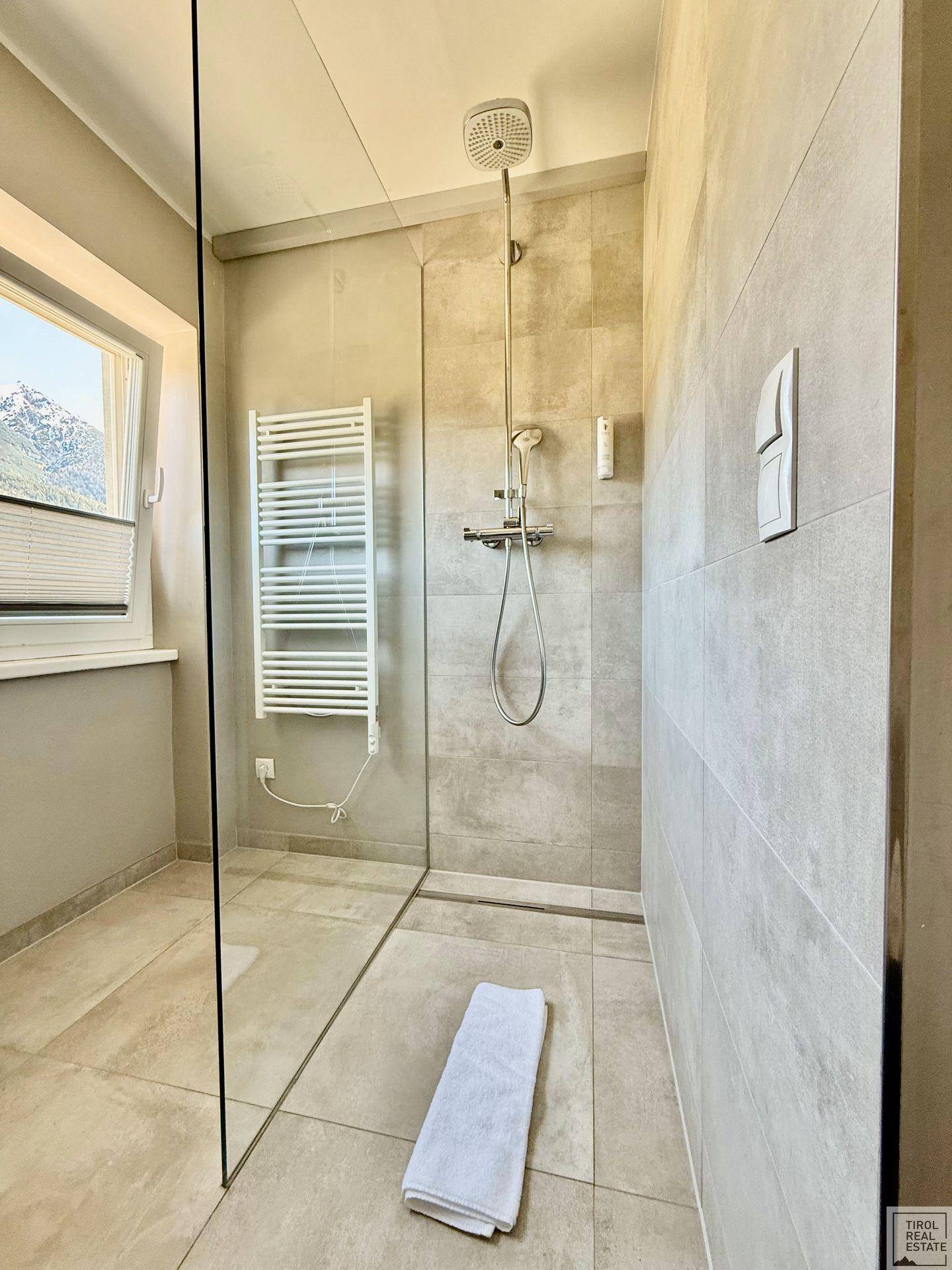 Ebenerdige Dusche mit Glasabtrennung und modernen Fliesen im Badezimmer.