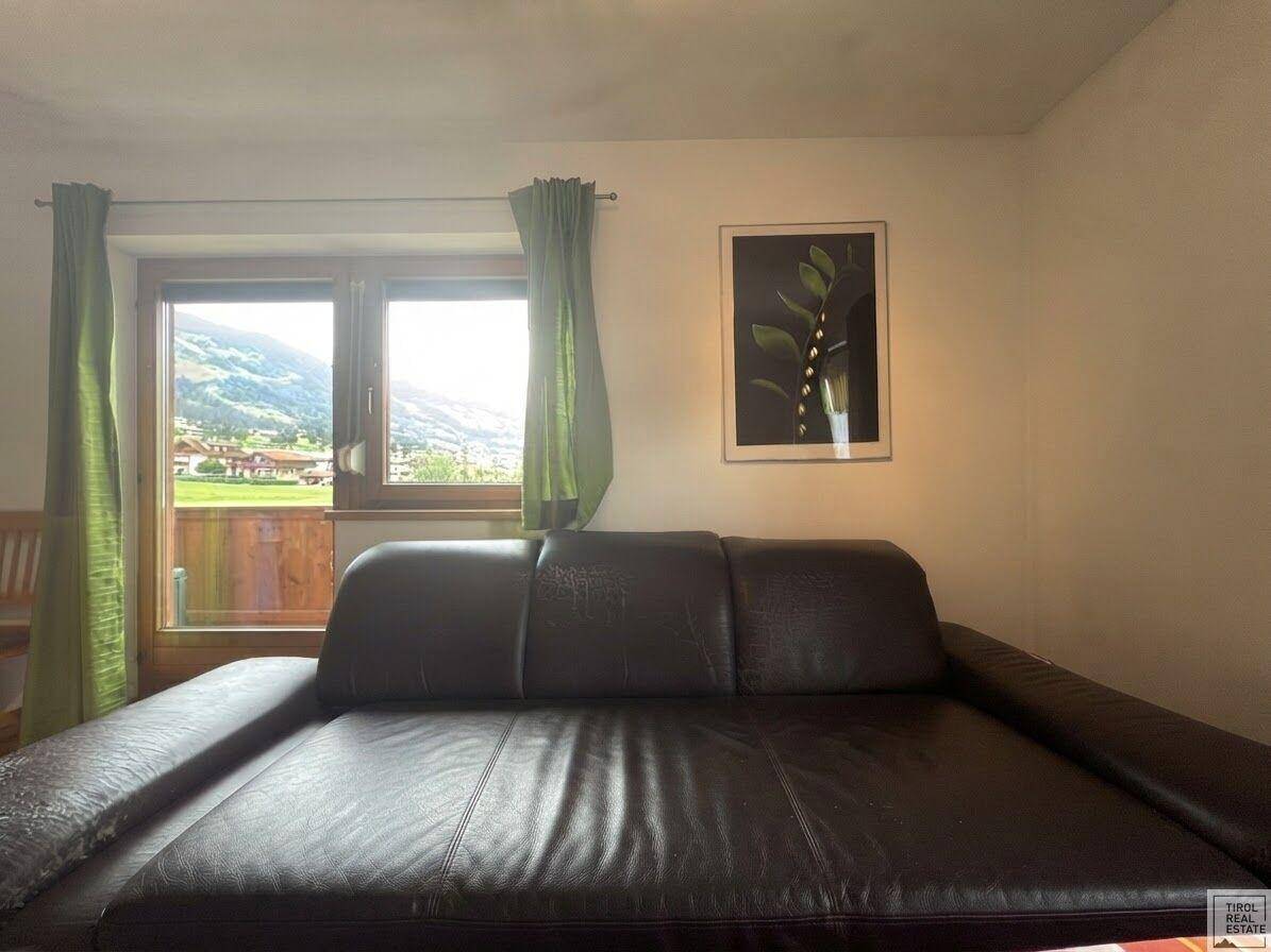 Bequemes Ledersofa im Wohnzimmer mit direktem Blick auf die umliegende Berglandschaft.