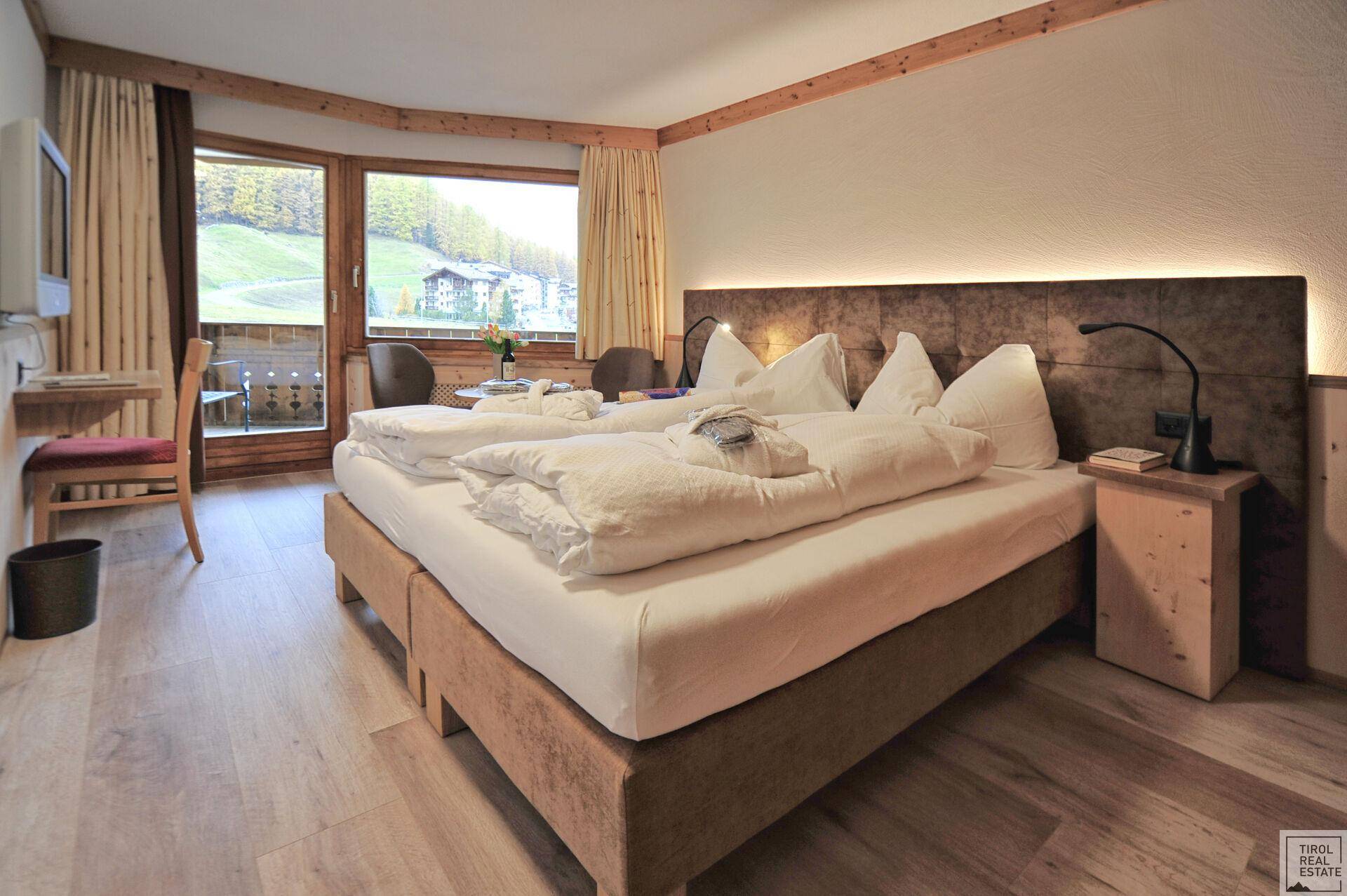 Geräumiges Schlafzimmer mit Doppelbett, Balkonzugang und einem schönen Blick auf die umliegende Landschaft.