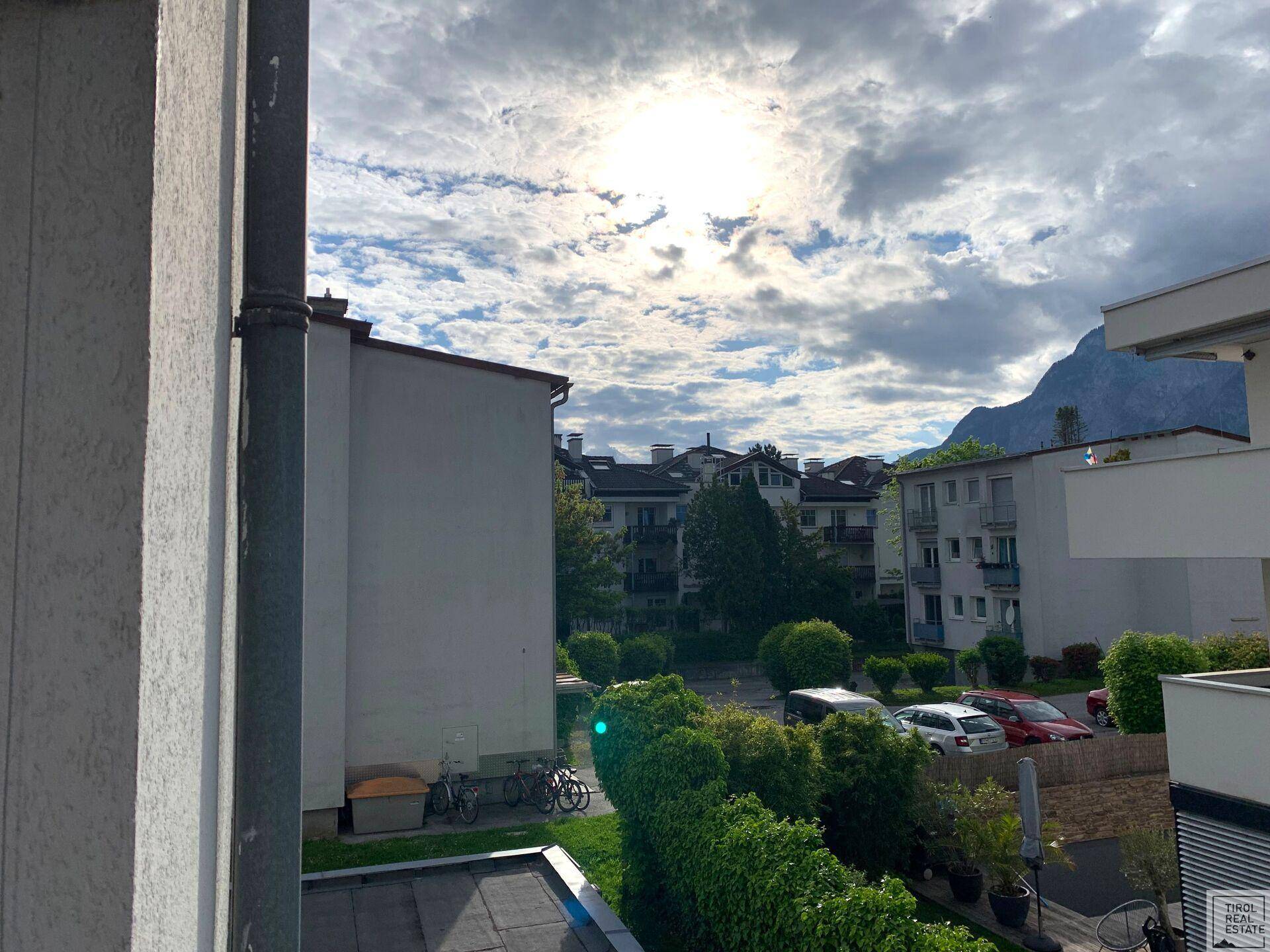 Sonniger Blick auf die umliegende Wohnbebauung mit viel Grün und einem hellen Himmel.