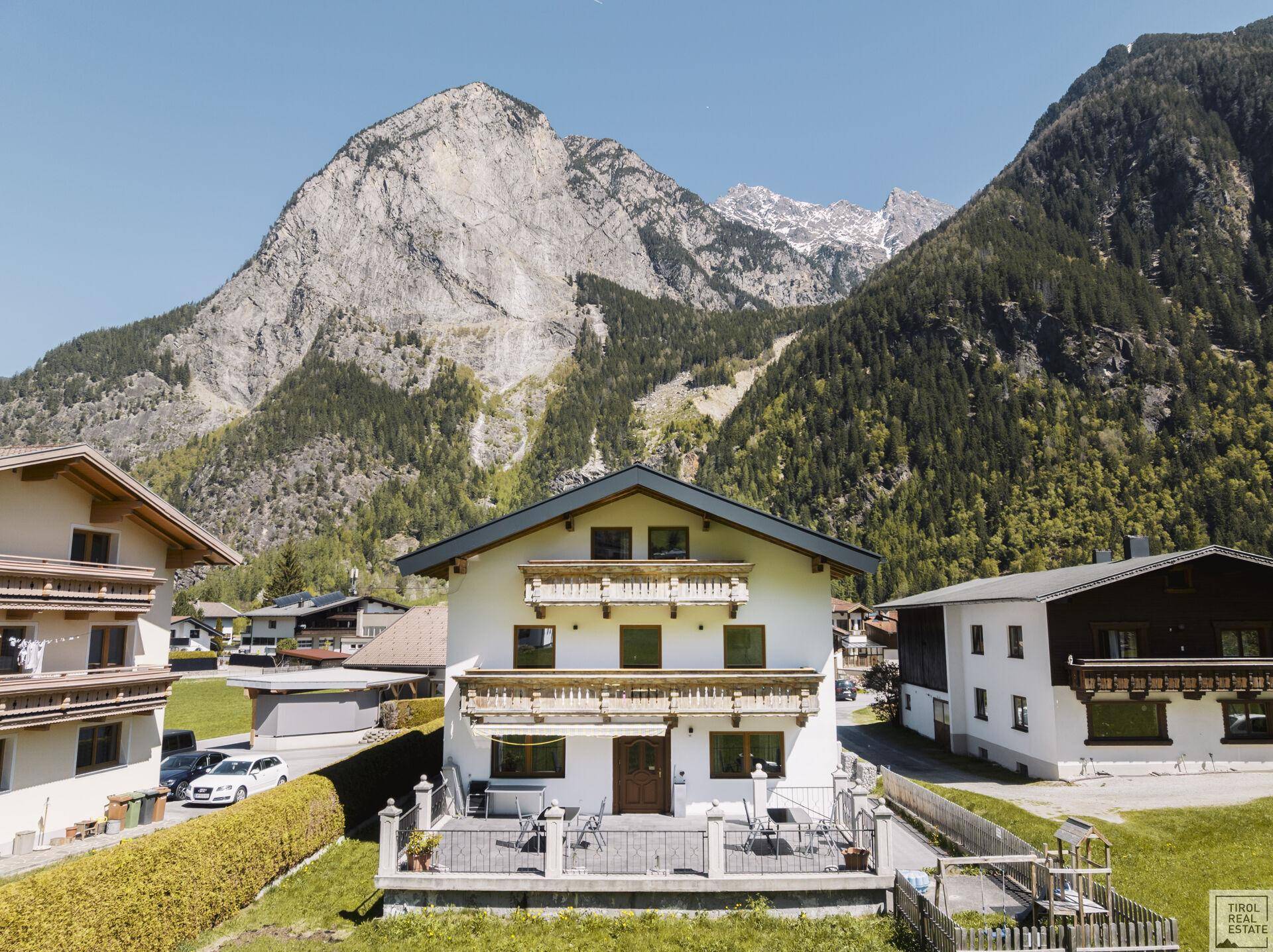 Traditionelles Wohnhaus in alpiner Umgebung mit großem Garten und beeindruckendem Bergblick.