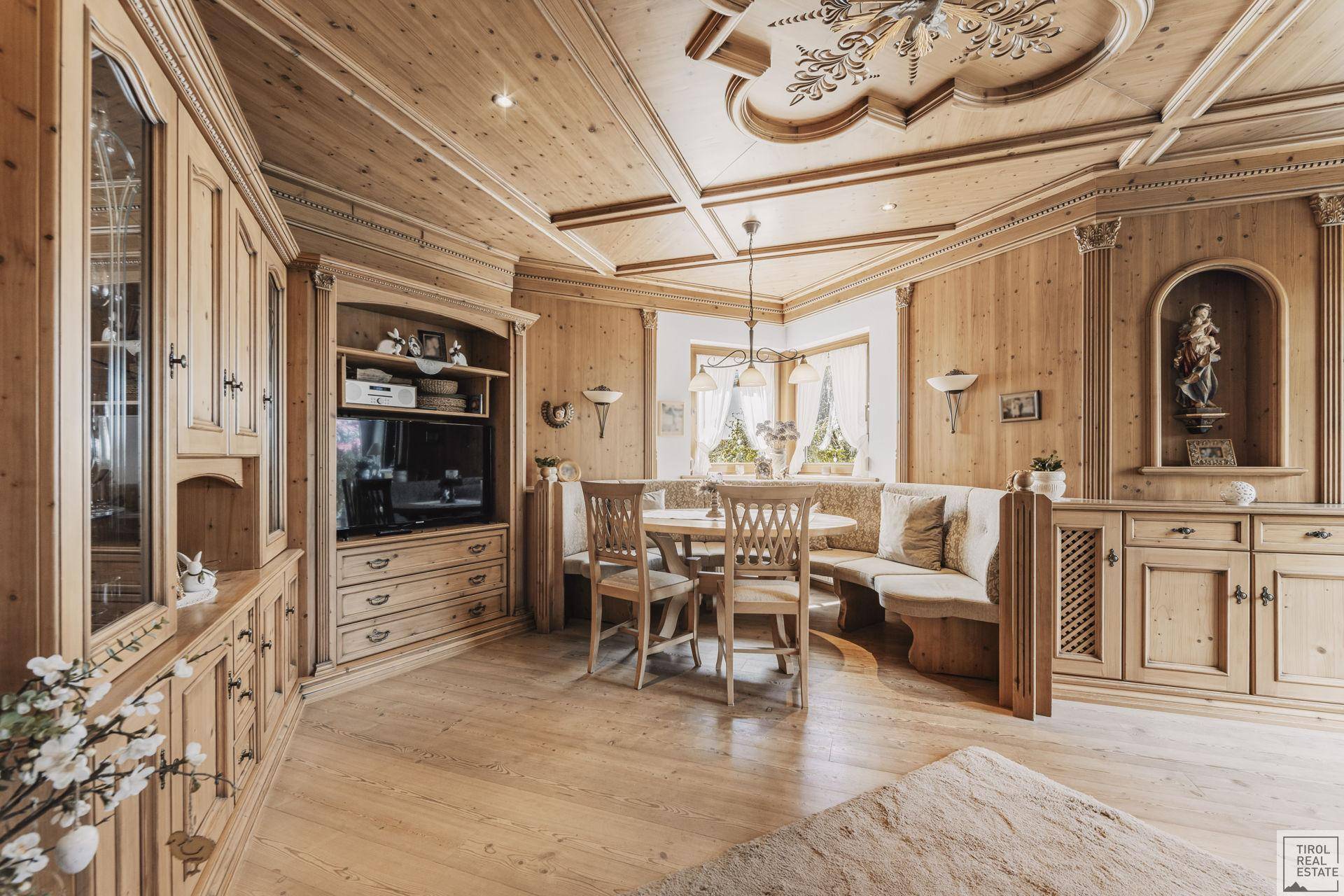 Geräumiges Wohnzimmer mit Holzeinbauten, TV-Möbeln und traditioneller Deckenverzierung.