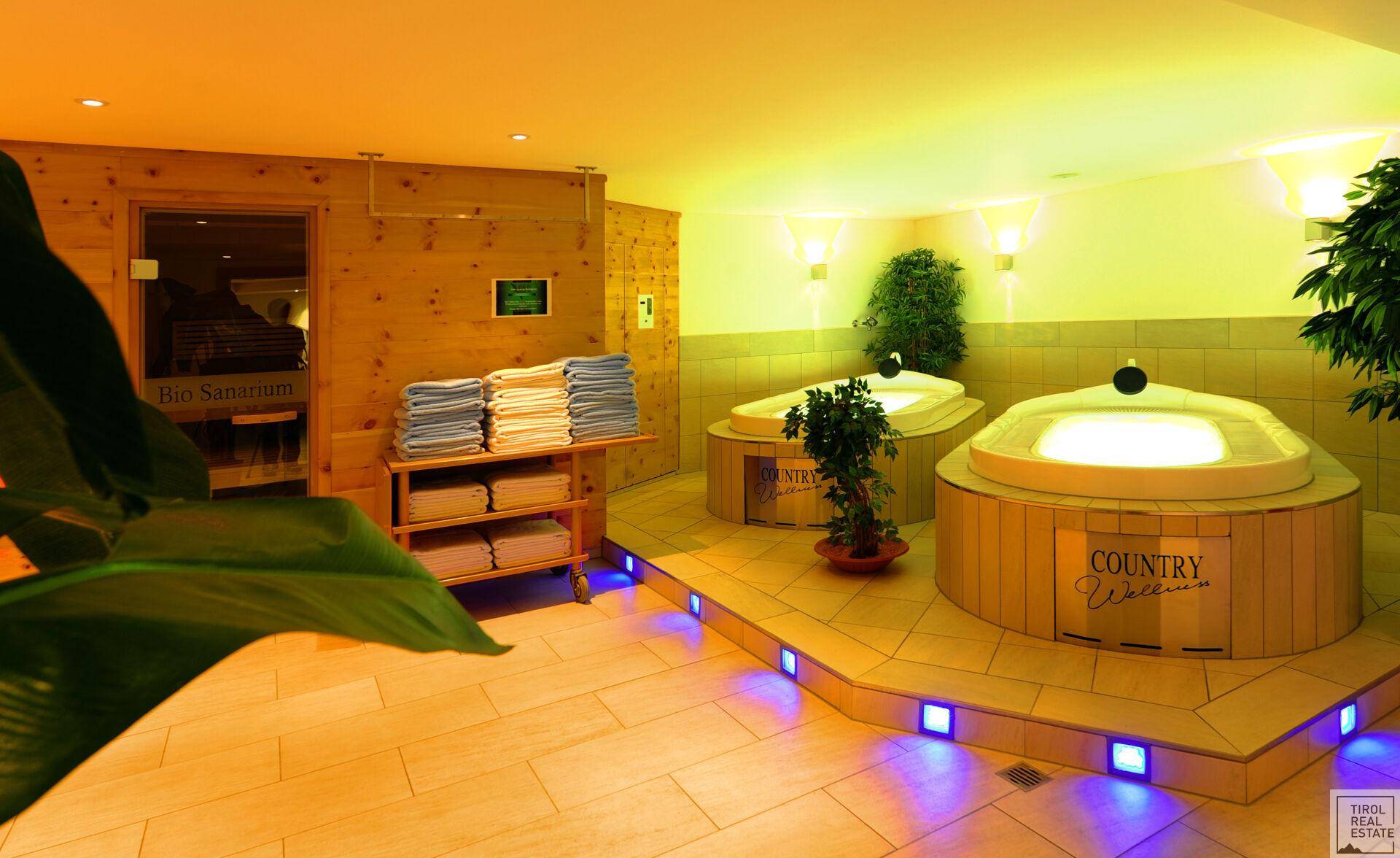 Entspannender Wellnessbereich mit Whirlpools, frischen Handtüchern und Pflanzen, die eine natürliche Umgebung schaffen.