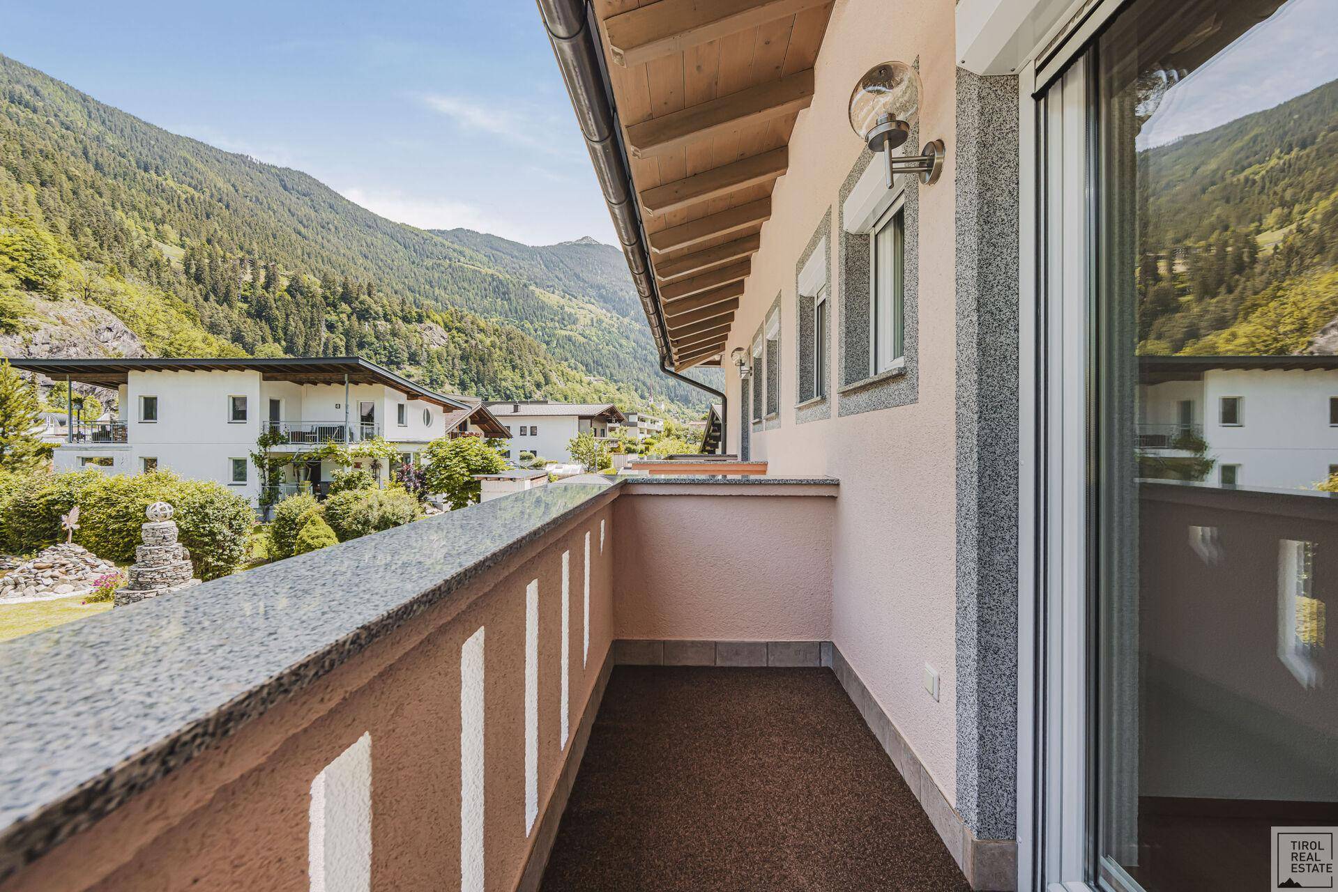 Balkon mit Granitgeländer und weitem Blick auf die umliegende Berglandschaft.