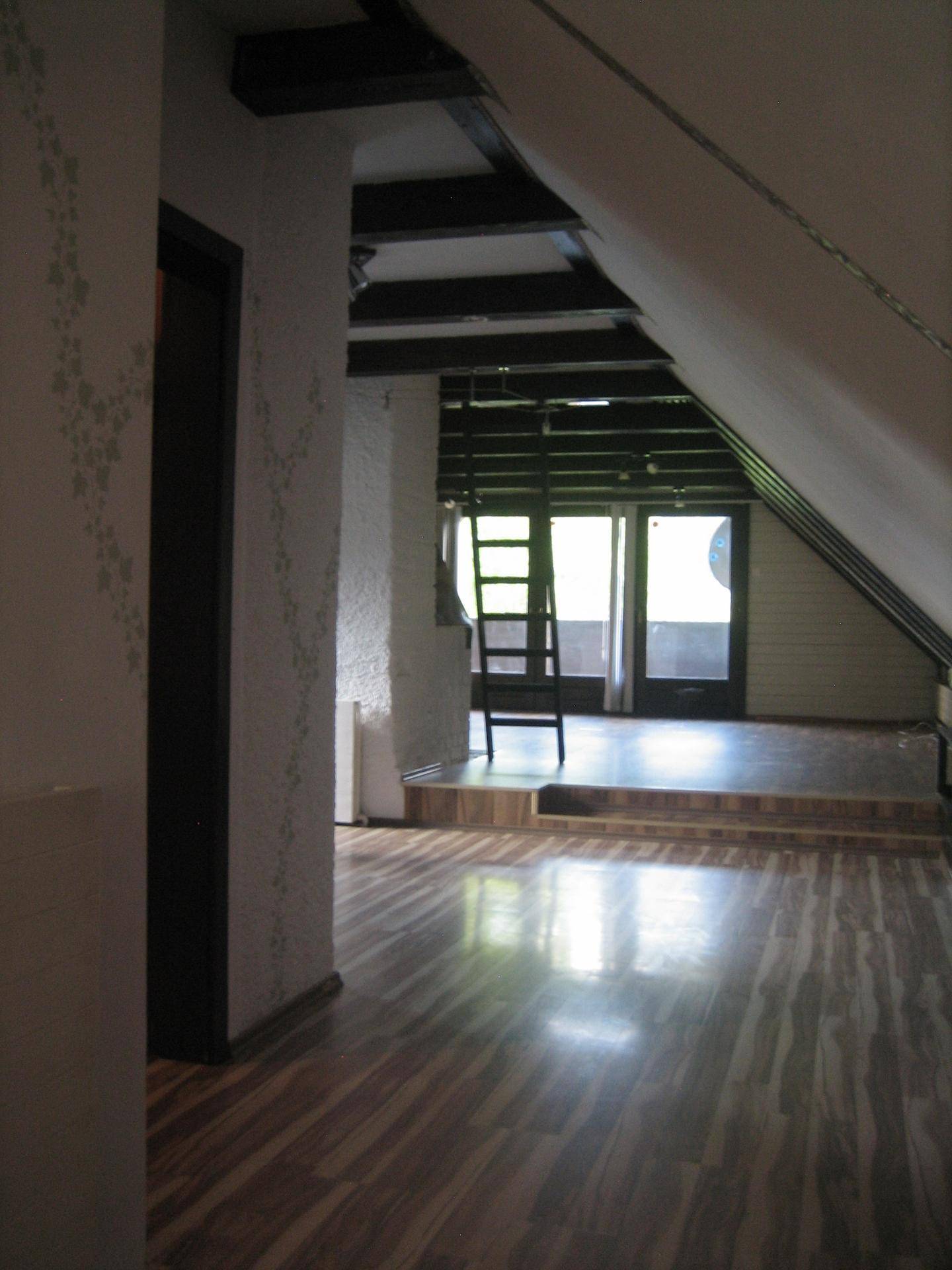 Heller Flurbereich mit Laminatboden und Blick in den offenen Dachgeschoss-Wohnbereich.