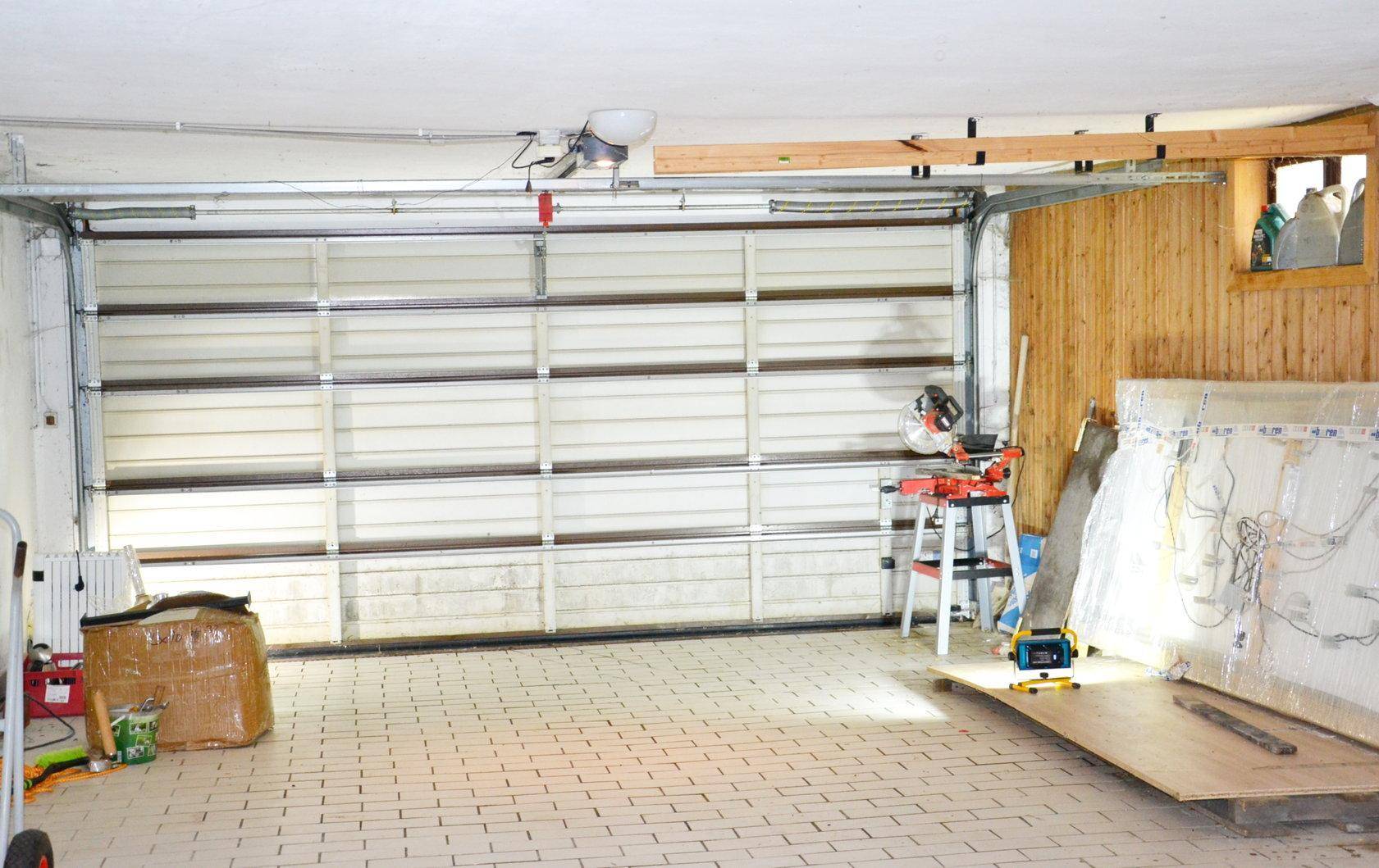 Geräumige Garage mit Fliesenboden und Sektionaltor.