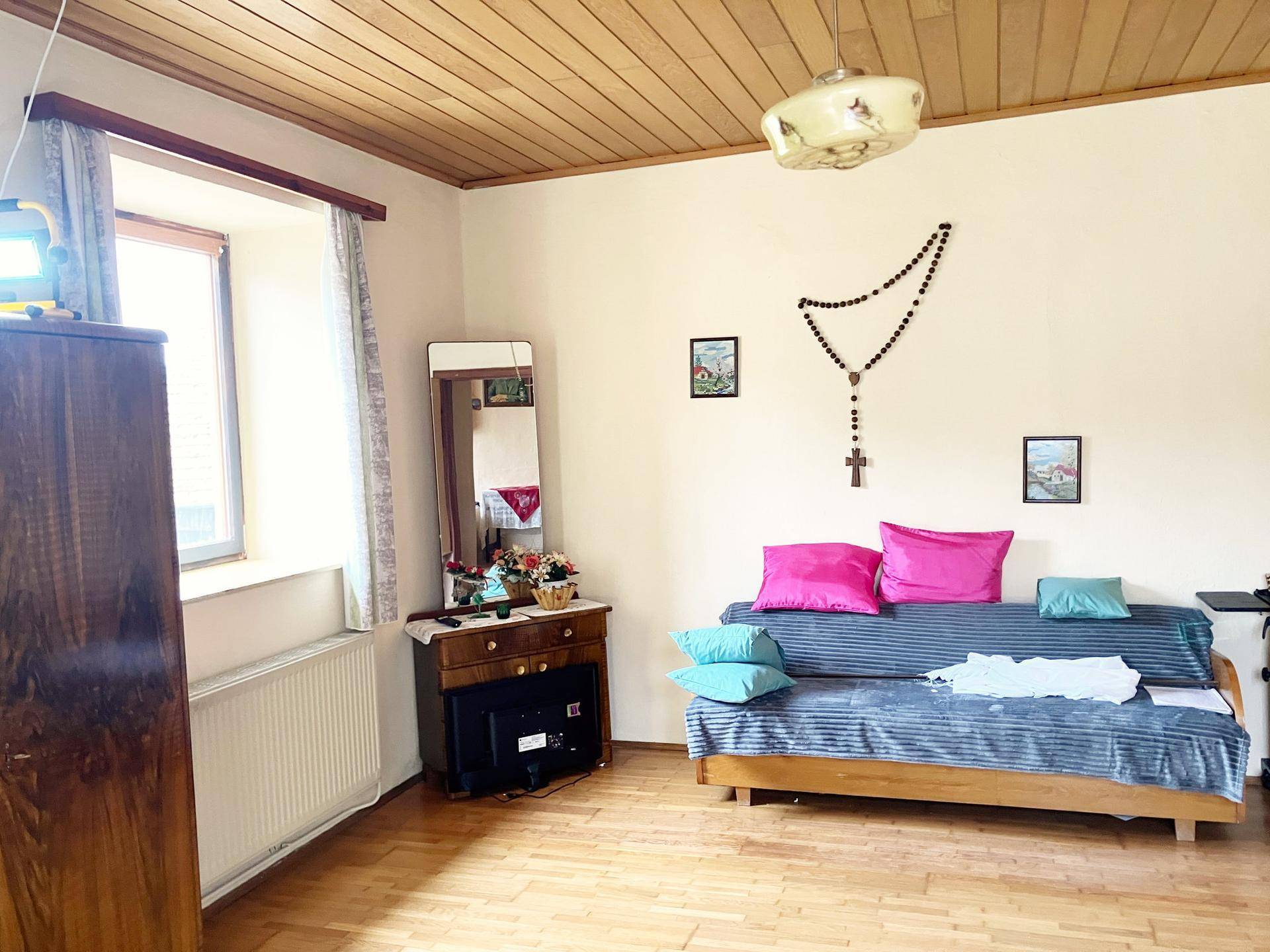 Wohnzimmer mit Sofa, Holzdecke und traditioneller Dekoration.