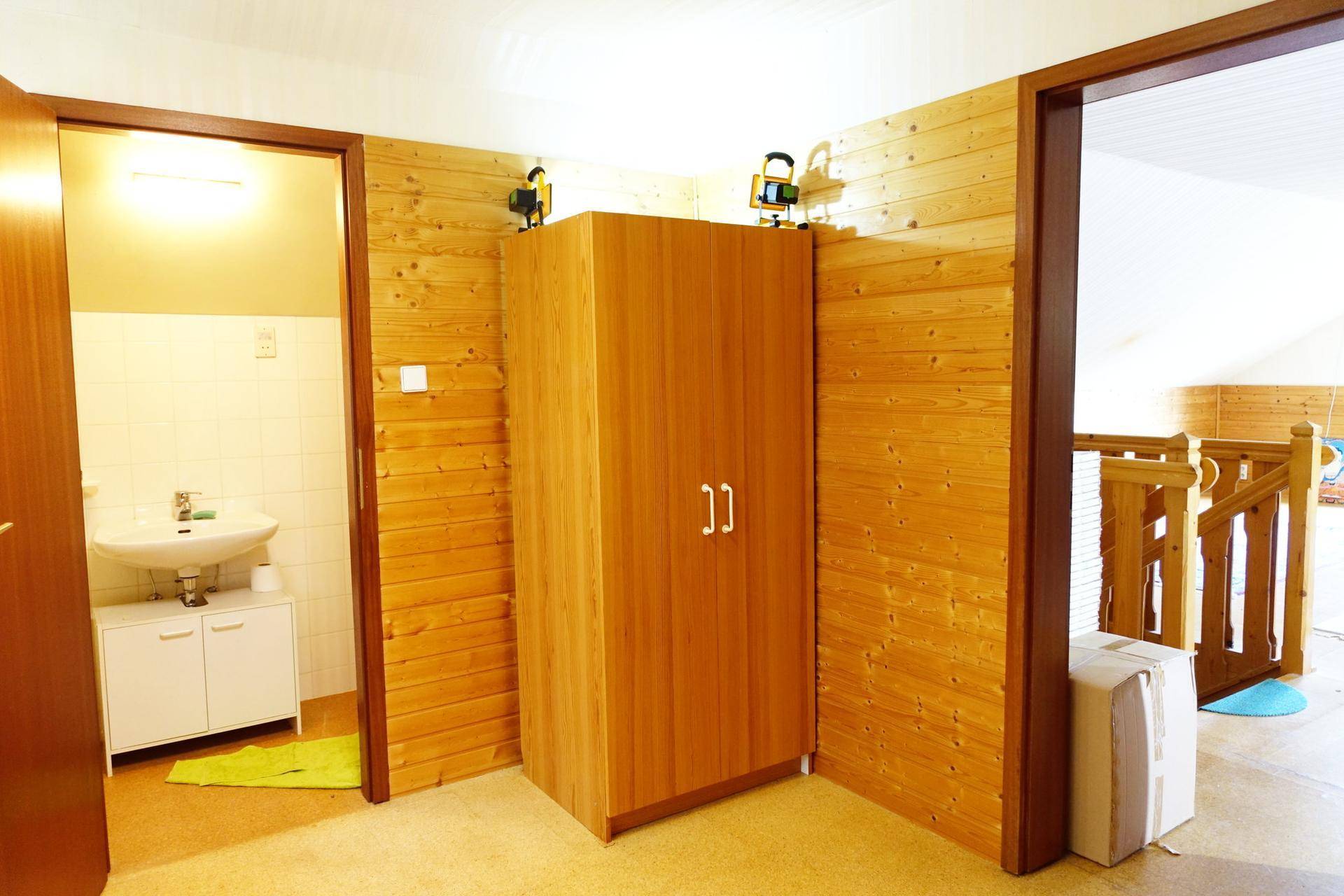 Flurbereich im Obergeschoss mit Schrank und Zugang zu einem Badezimmer.