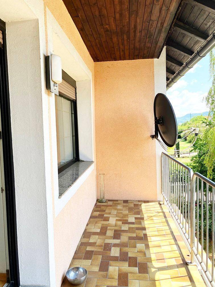 Schmaler Balkon mit Fliesenboden und Metallgeländer, ideal für einen kleinen Außenbereich.