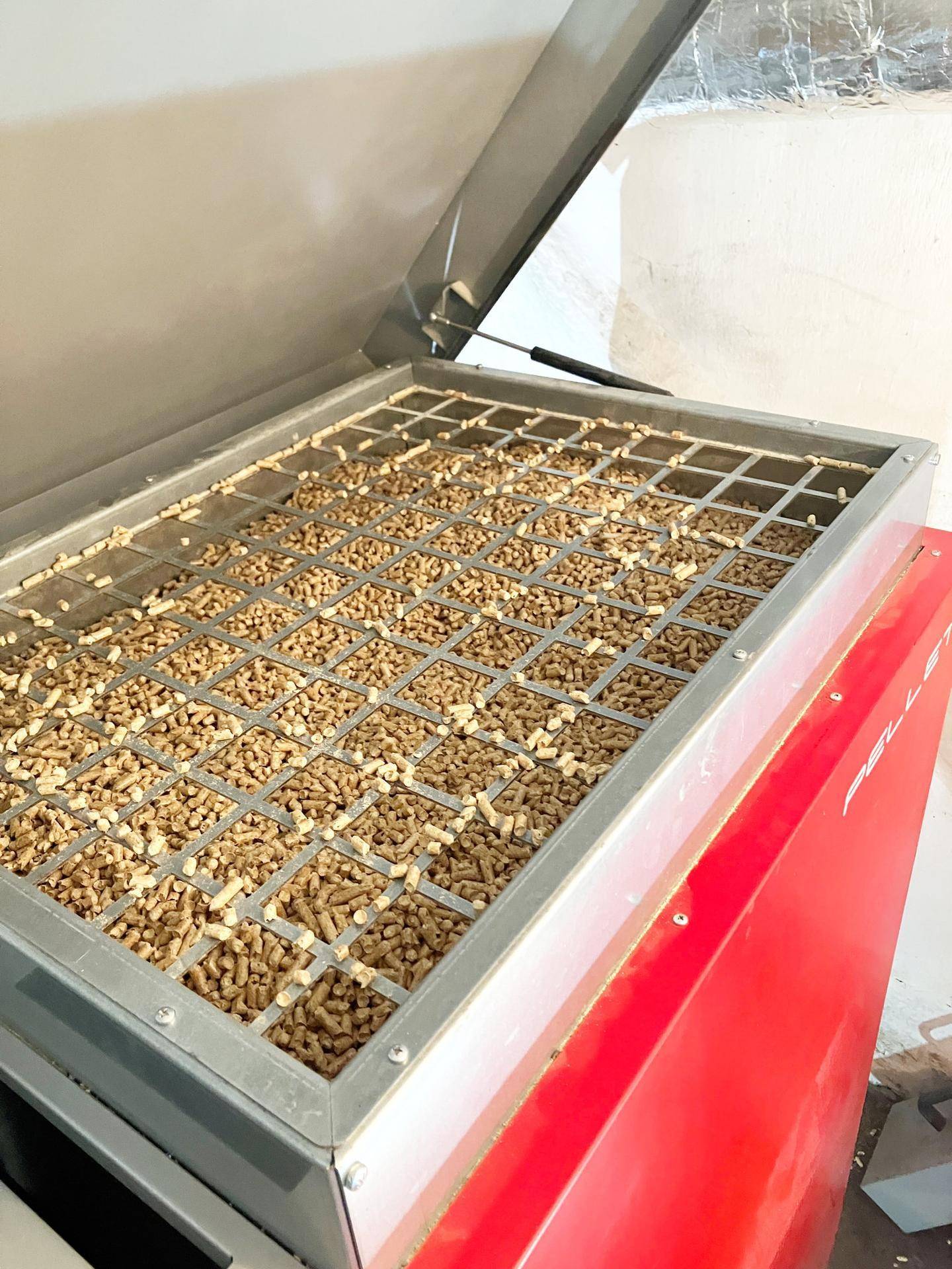 Detailansicht des Pelletkessels mit Holzpellets im Behälter.