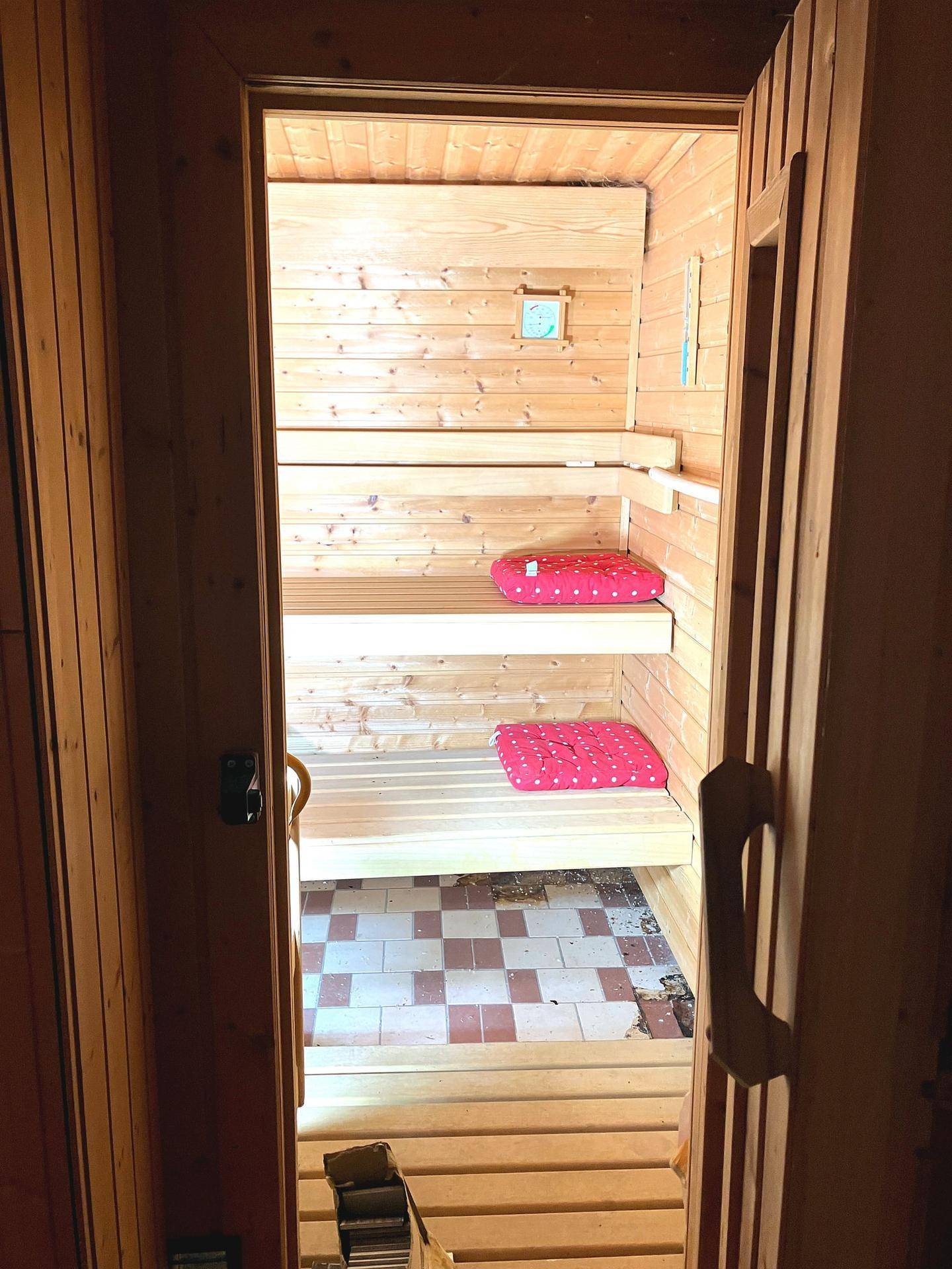 Gemütliche Holzsauna mit Bänken und traditionellem Saunaofen.