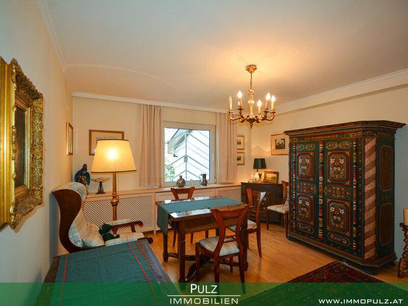 Esszimmer mit Holzboden, traditionellem Schrank und Kronleuchter.