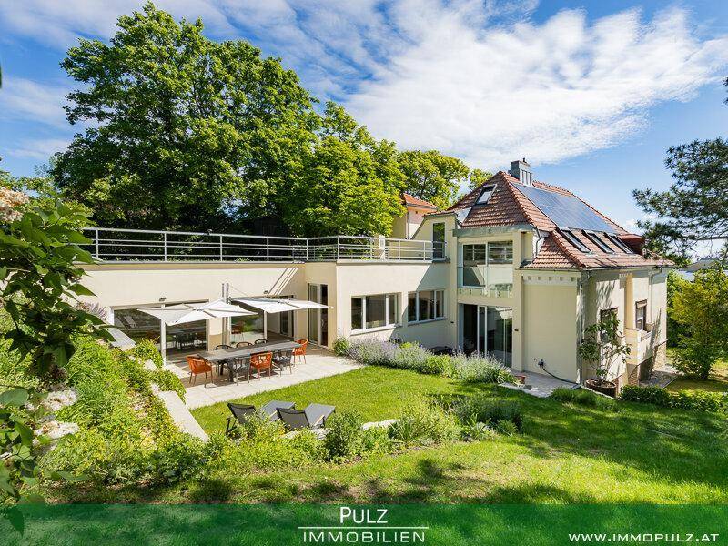 Historische Villa mit moderner Erweiterung, großem Garten und Photovoltaikanlage auf dem Dach.