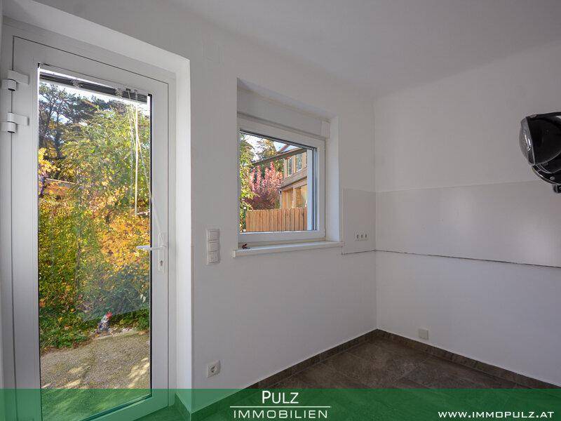 Kleiner Raum mit direktem Zugang zum Garten und Fenster, ideal als Hauswirtschaftsraum.