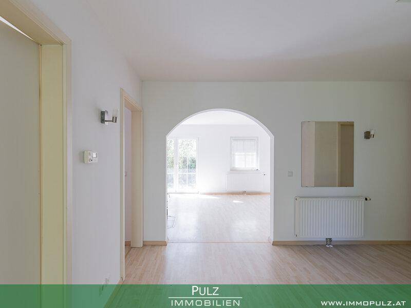 Heller Flurbereich mit Rundbogen und Spiegel, führt in den Wohnbereich mit Terrassenzugang.