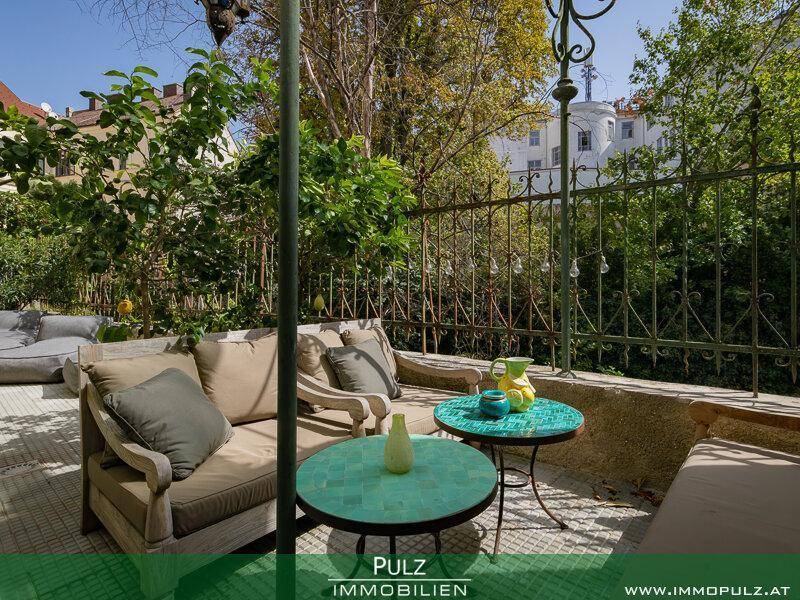 Gemütliche Terrasse mit Sitzgelegenheiten und üppiger Bepflanzung im Freien.