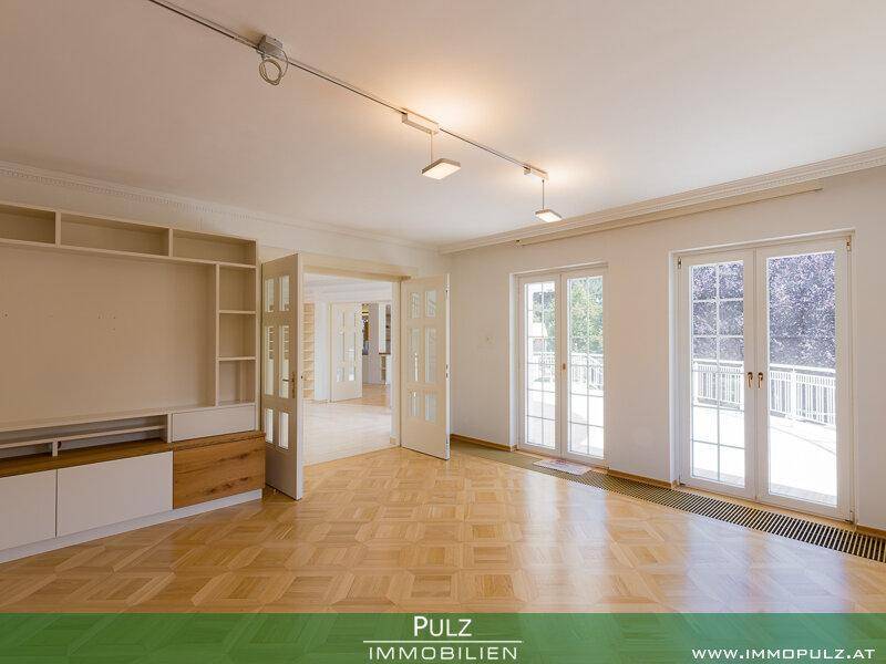Helles Wohnzimmer mit Parkettboden, Einbauschrank und direktem Zugang zum Balkon.