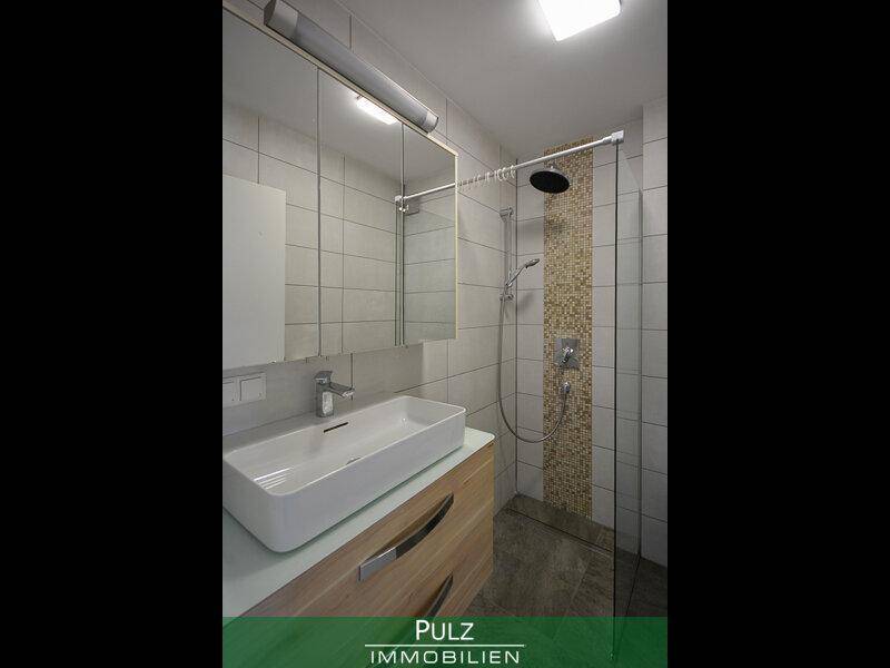 Modernes Badezimmer mit begehbarer Dusche, Regendusche und elegantem Waschtisch.