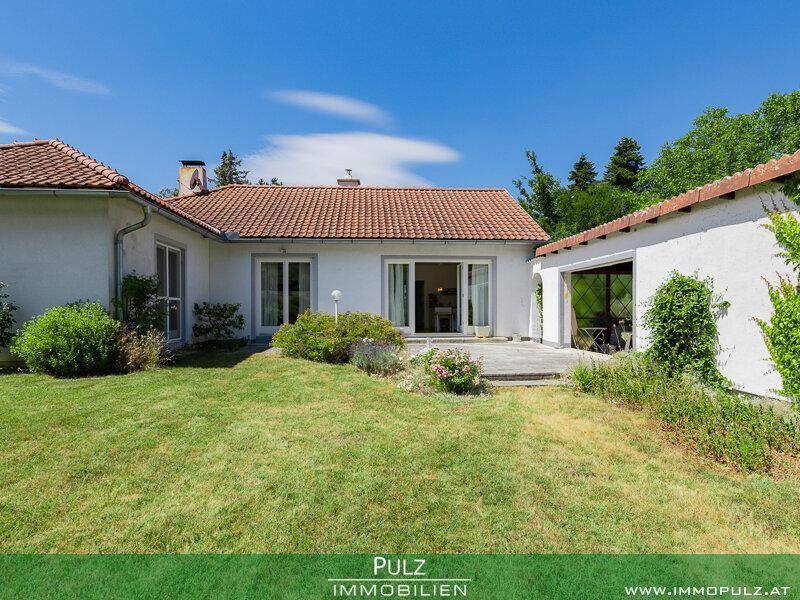 Rückseite des Hauses mit Zugang zum Garten und einer kleinen Rasenfläche.