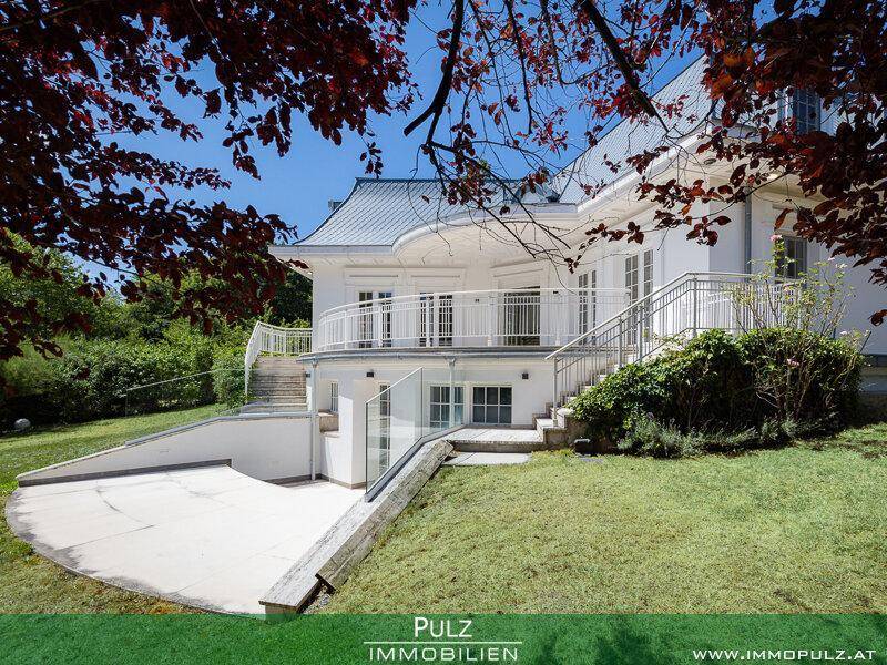 Seitlicher Blick auf die Villa mit Treppen, Rampe und Zugang zum Untergeschoss.