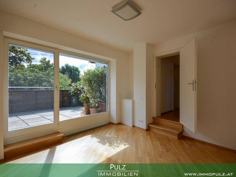 Heller Raum mit Parkettboden und Zugang zu einer Terrasse, ideal als Schlafzimmer nutzbar.
