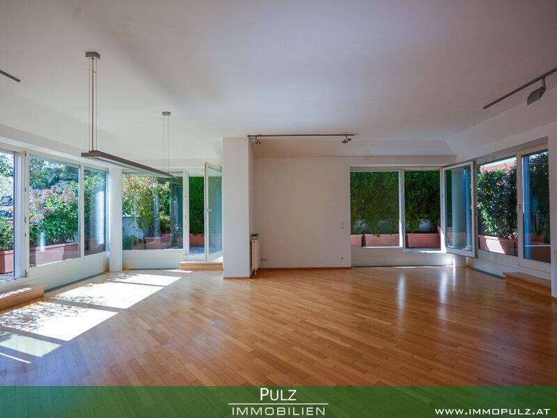 Helles und geräumiges Wohnzimmer mit großen Fenstern und Zugang zur Terrasse.
