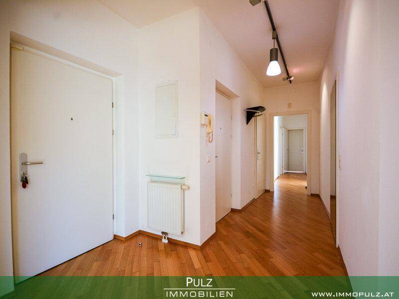 Heller Eingangsbereich mit Holzboden und Zugang zu verschiedenen Zimmern der Wohnung.