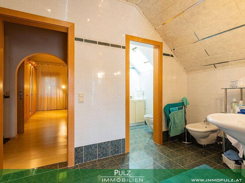 Badezimmer mit Bidet, Waschbecken und Zugang zu einem weiteren Raum.