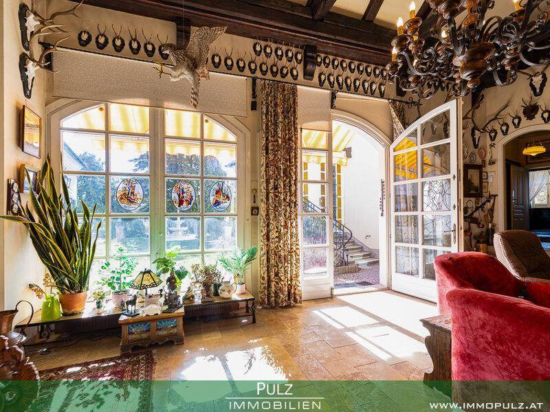 Detailansicht der großen Fenster mit Buntglas und dem sonnigen Zugang zum Gartenbereich.