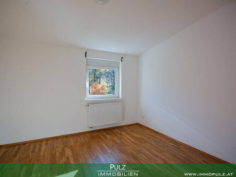 Geräumiges Zimmer mit hellem Parkettboden und Fenster, das viel Tageslicht hereinlässt.