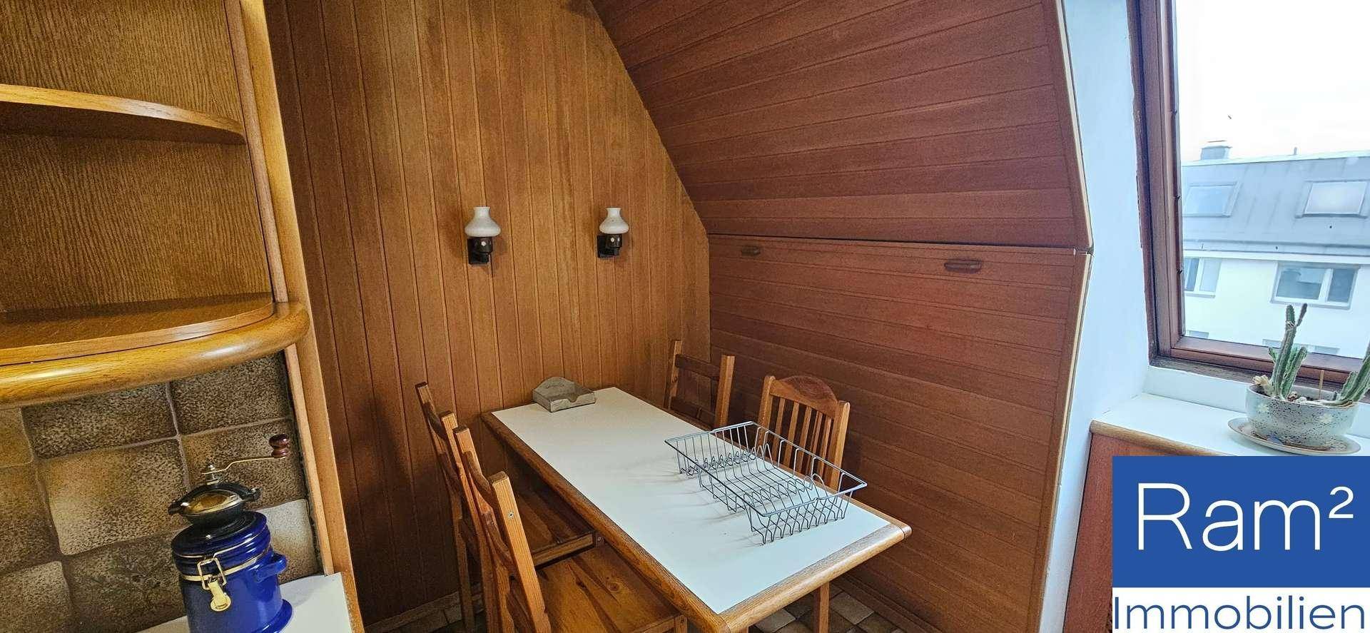 Gemütlicher Essbereich mit Holzvertäfelung und Blick aus dem Fenster.