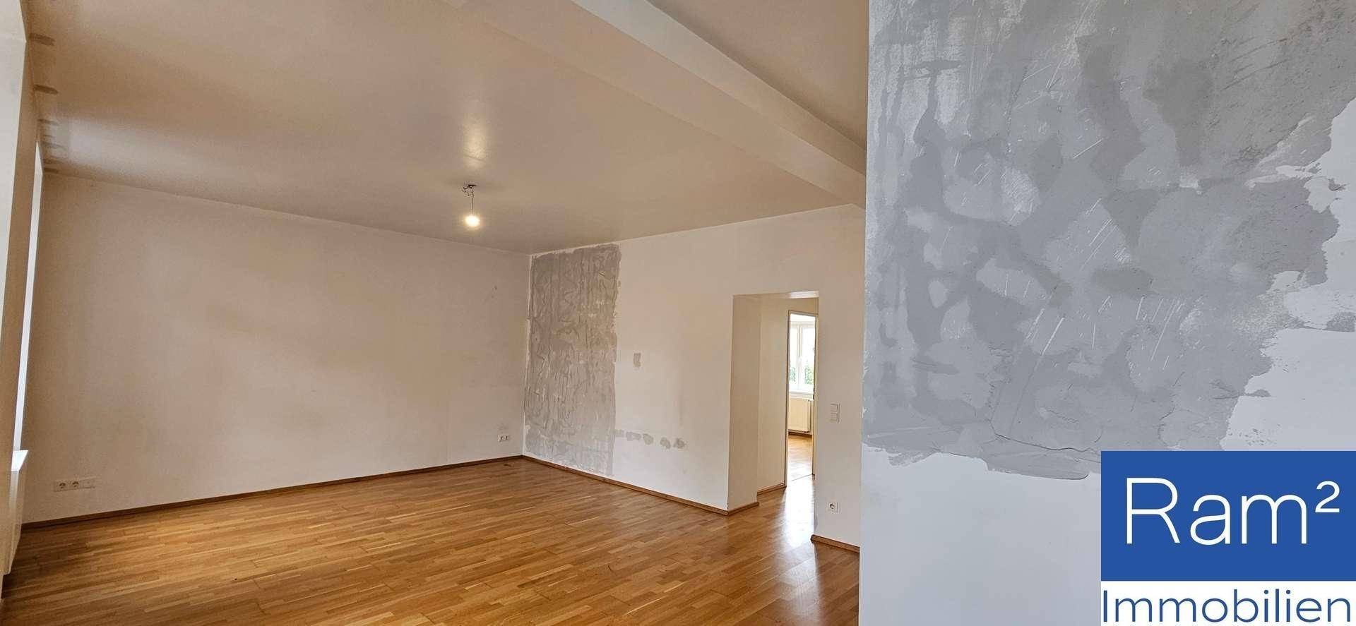 Zimmer mit Parkettboden und Wänden, die auf Renovierungsbedarf hinweisen.