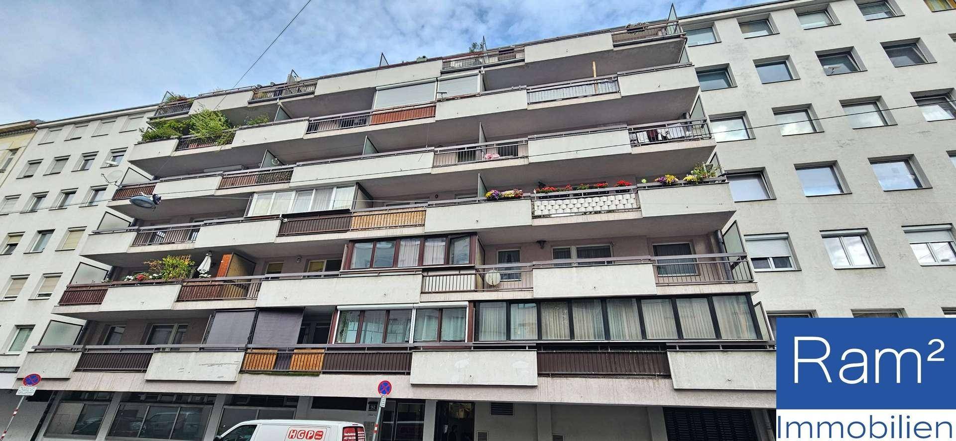 Fassade eines Mehrfamilienhauses mit zahlreichen Balkonen und Fenstern.