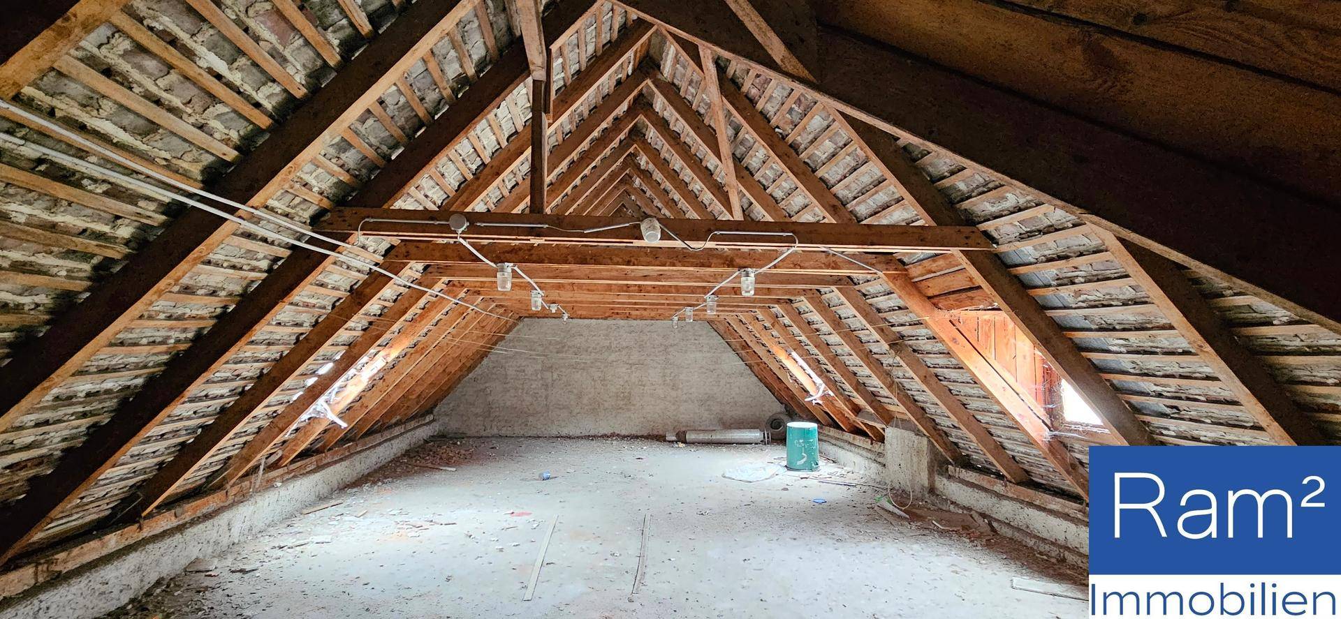 Unausgebauter Dachboden mit sichtbaren Holzbalken und Dachschrägen, bietet Ausbaupotenzial.