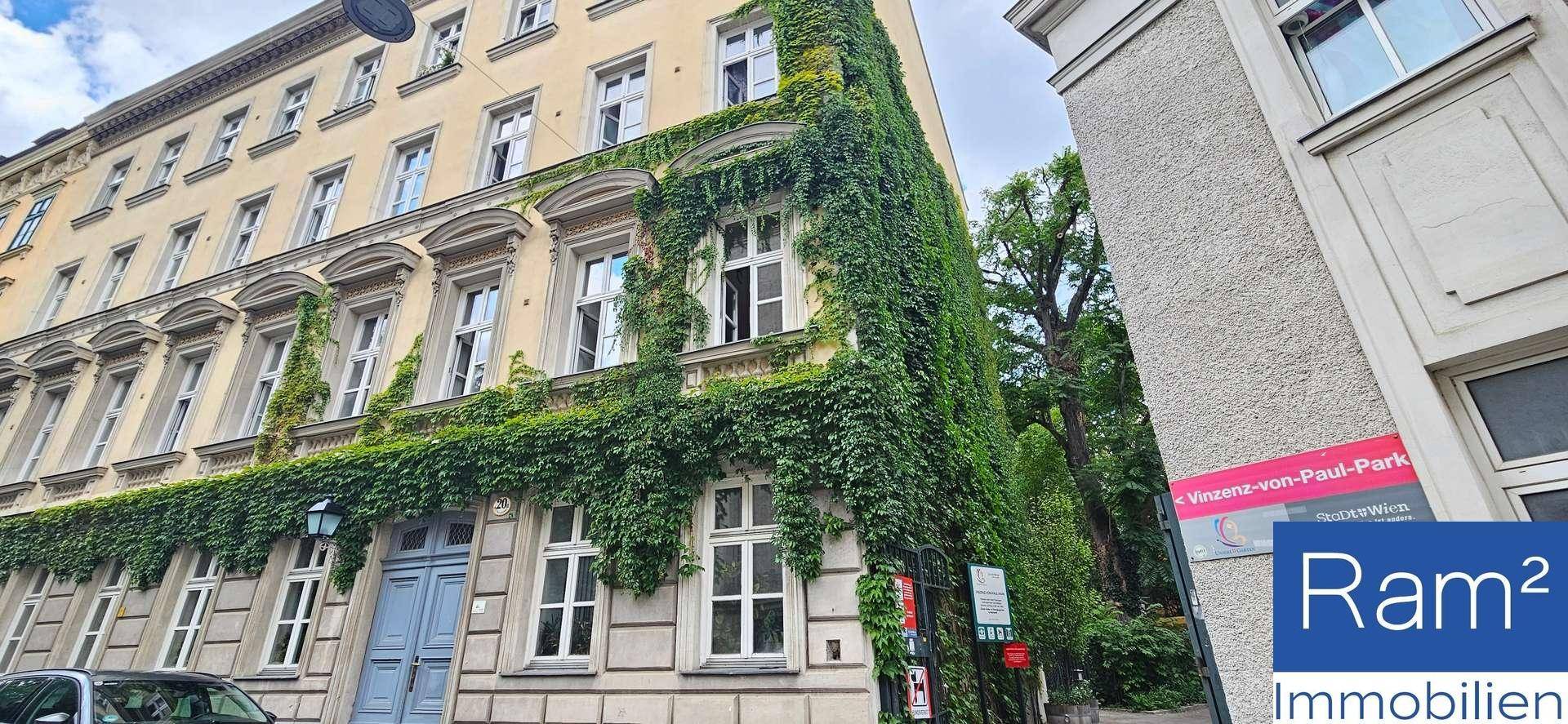 Historisches Gebäude mit Efeubewuchs und klassischen Fenstern in einer städtischen Umgebung.