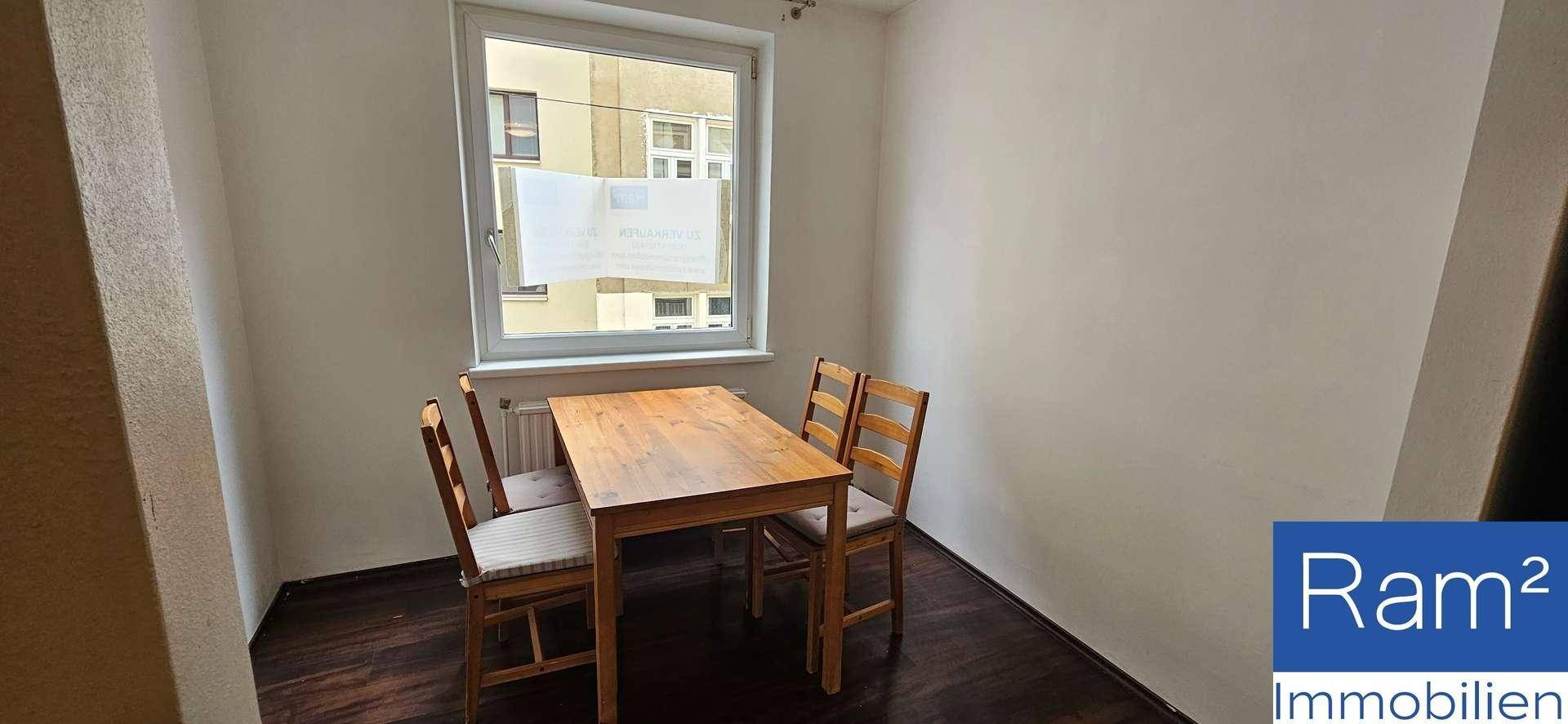 Gemütlicher Essbereich mit Holztisch und Stühlen, direkt am Fenster gelegen.