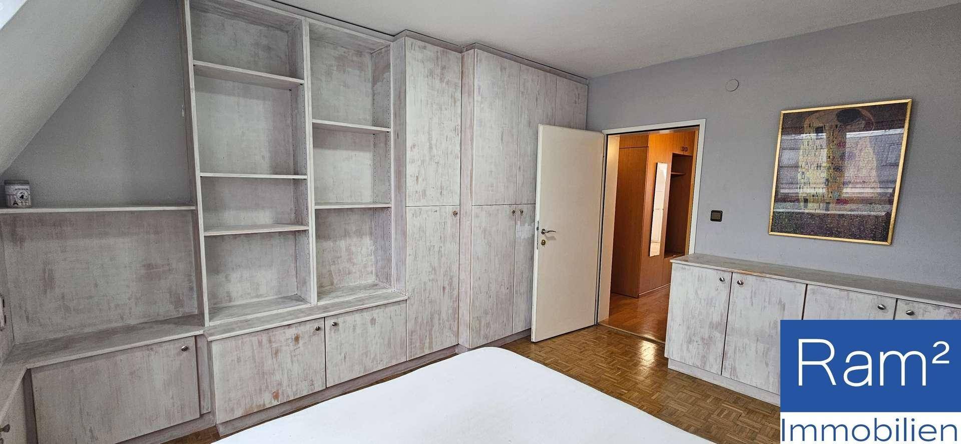 Schlafzimmer mit integrierten Holzschränken und Regalen, bietet viel Stauraum.