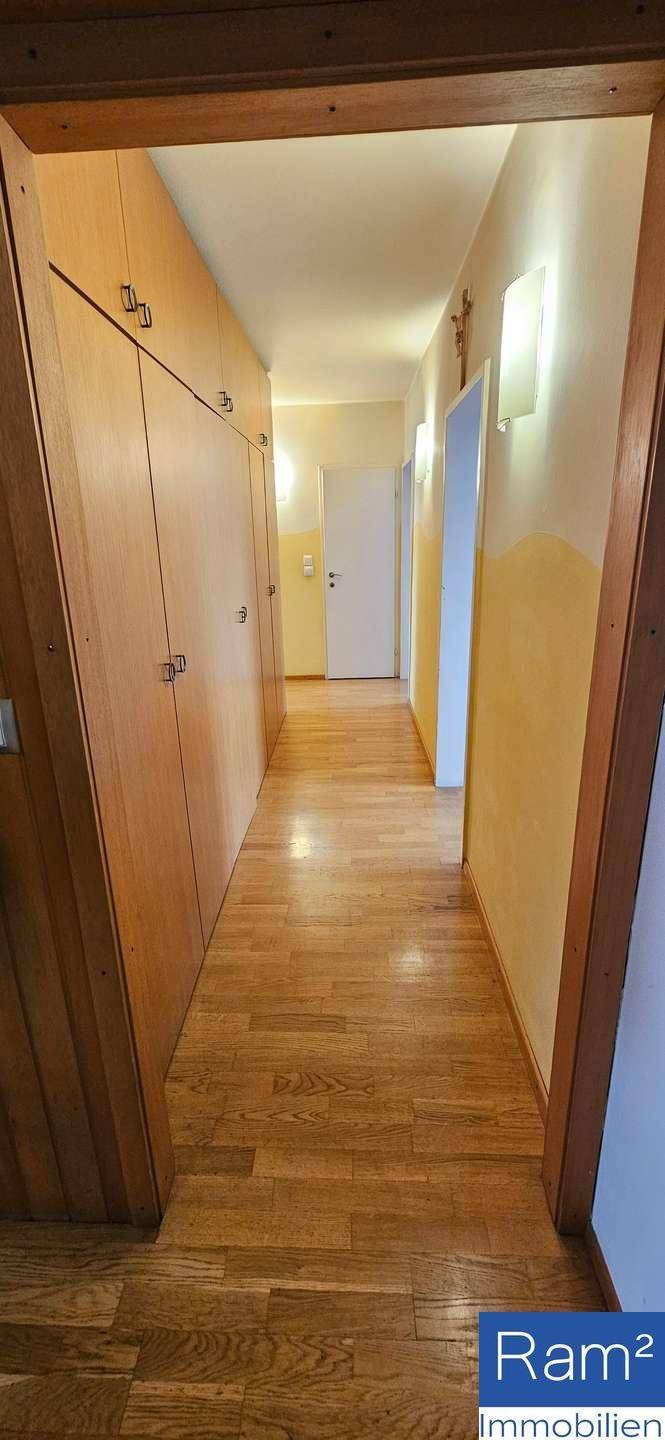 Langer Flur mit Holzvertäfelung und praktischen Einbauschränken.