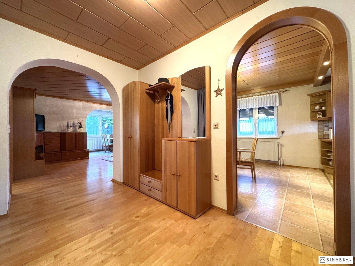 Flur mit Holzparkettboden, Einbauschrank und Blick in angrenzende Wohnbereiche.