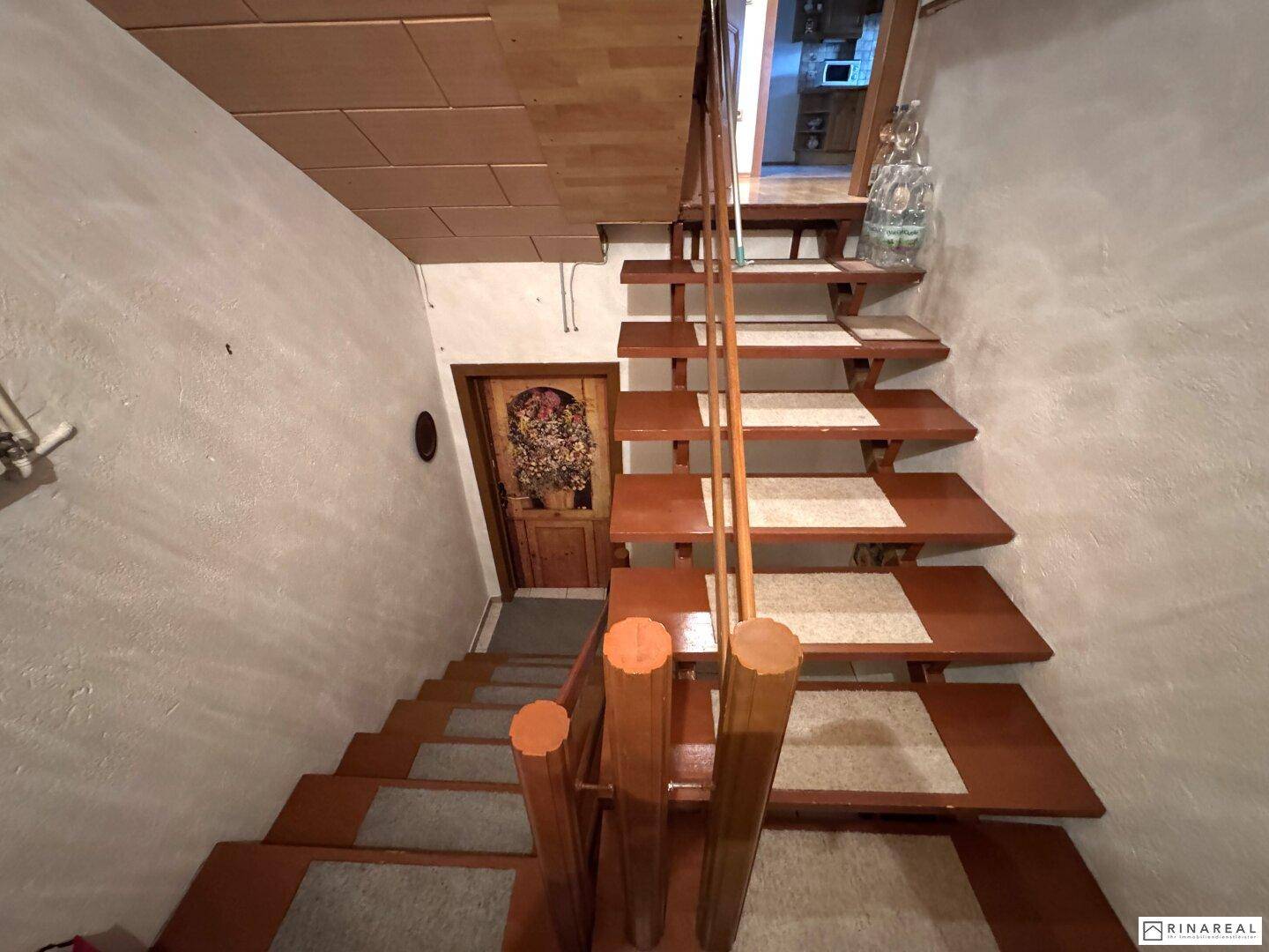 Holztreppe führt in den Kellerbereich, mit einfacher Gestaltung.