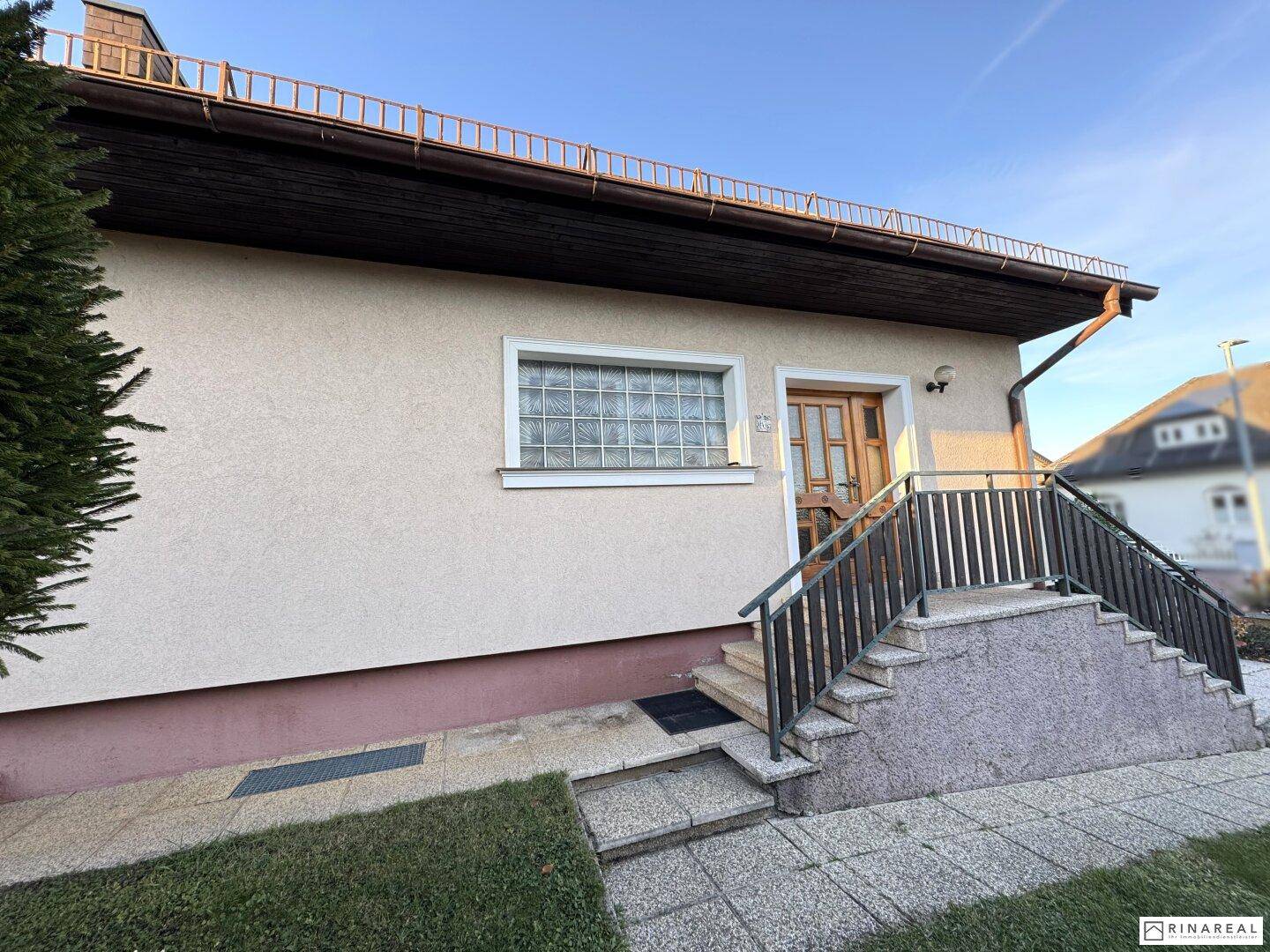 Eingangsbereich des Hauses mit Steintreppe und einer Glasbaustein-Fensterfront.