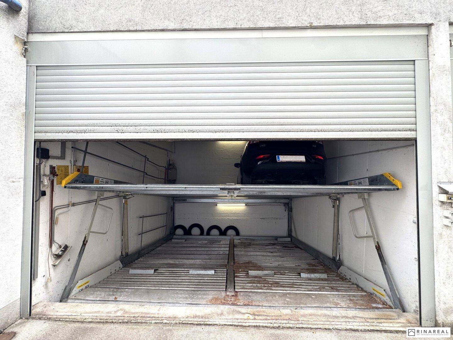 Detailansicht eines Garagenstellplatzes mit einem Fahrzeug auf der oberen Parkebene des Systems.
