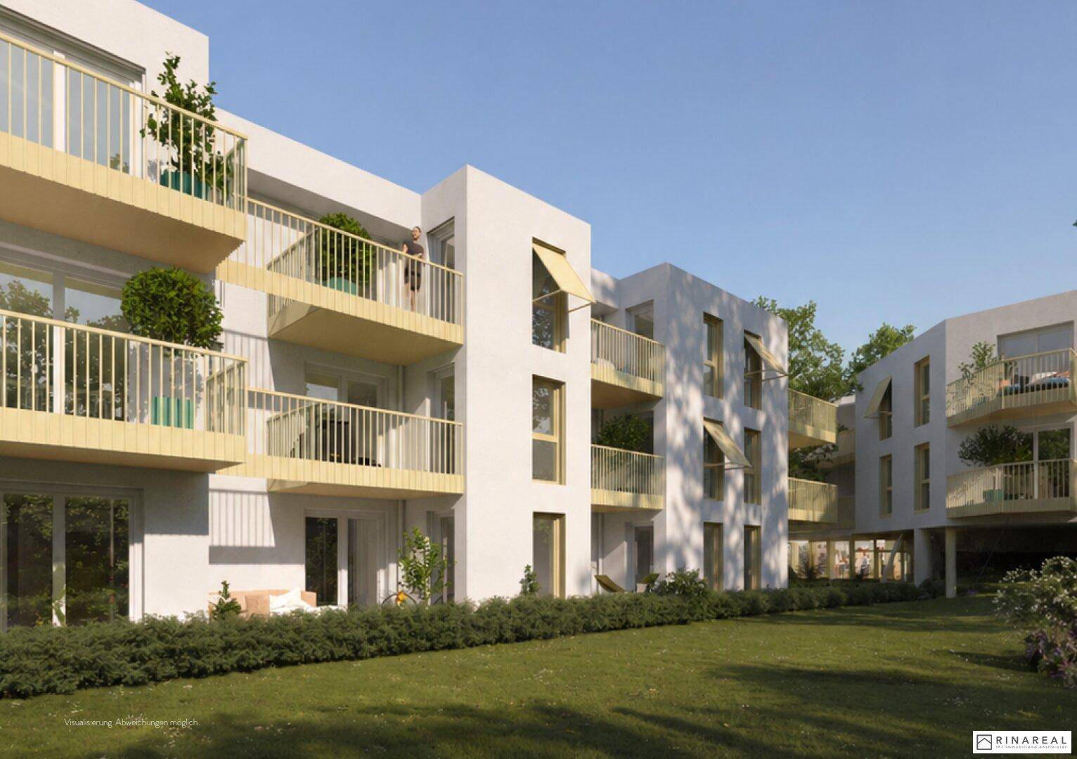 Moderne Architektur eines Wohngebäudes mit hellen Fassaden, Balkonen und gepflegter Grünfläche.