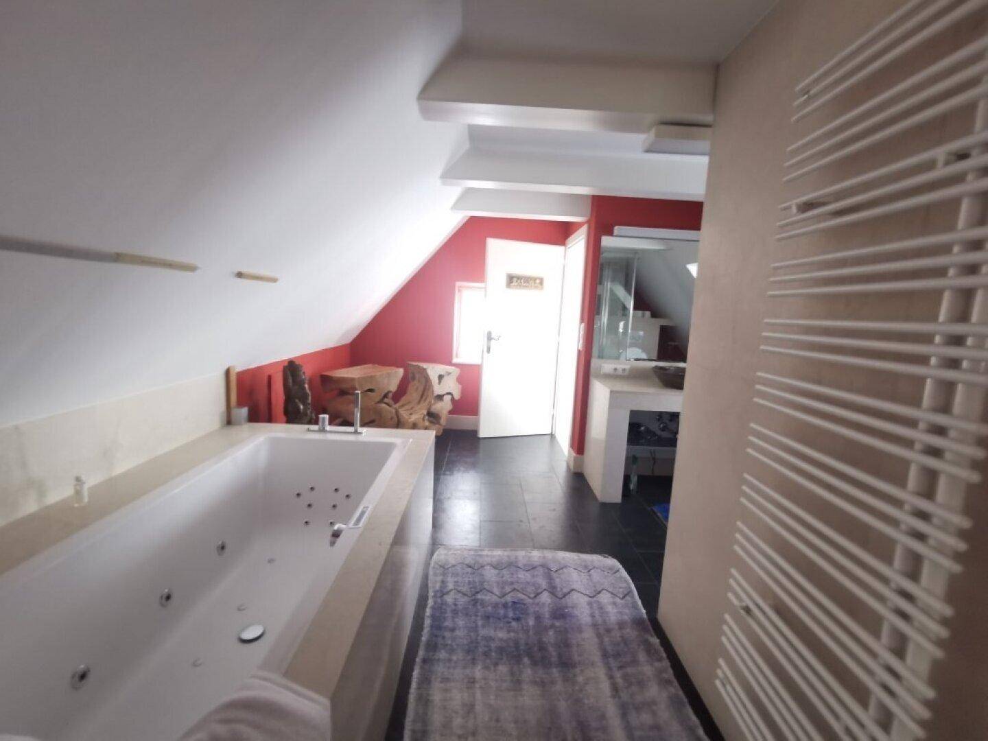 Geräumiges Badezimmer im Dachgeschoss mit Badewanne und beheiztem Handtuchhalter.