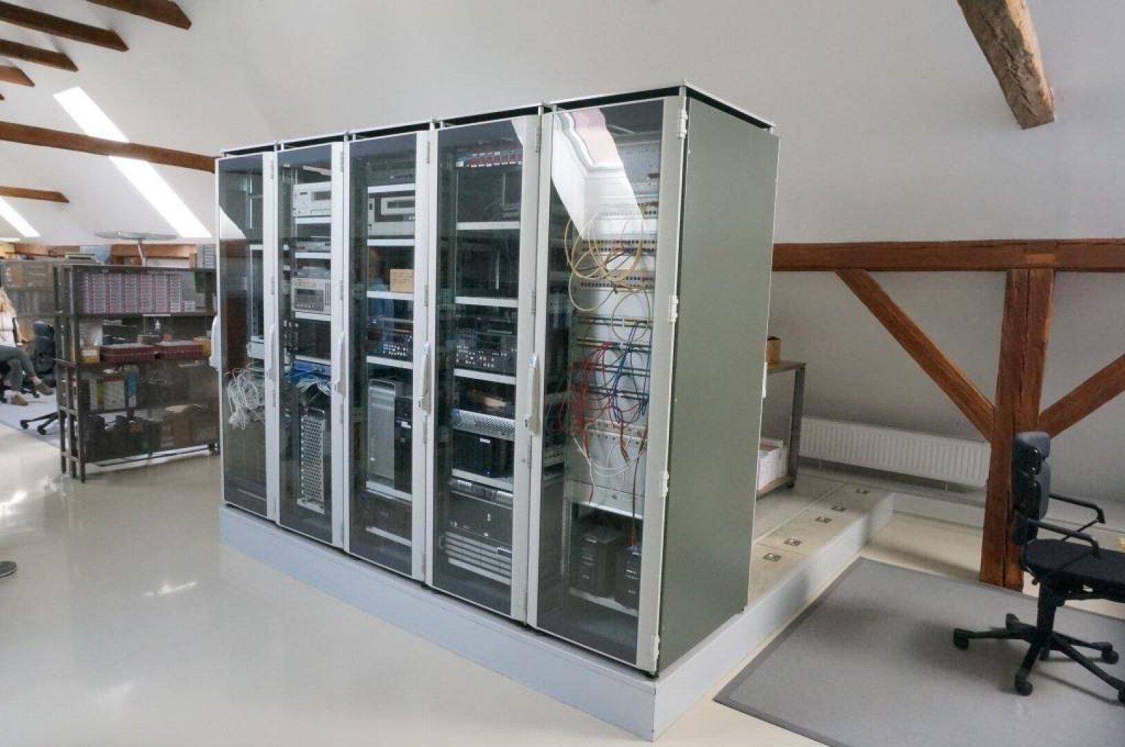 Serverraum mit mehreren Racks und sichtbaren Holzbalken im Dachgeschoss, ausgestattet für IT-Infrastruktur.